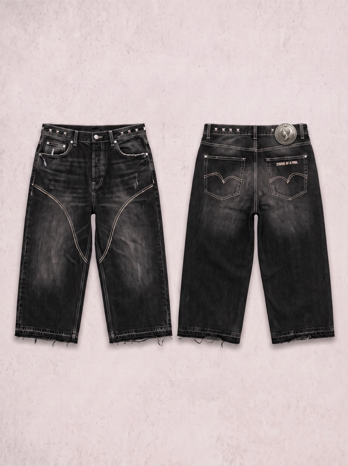 Black denim jorts with bone contrast stitching, a curved arc stitch across each thigh