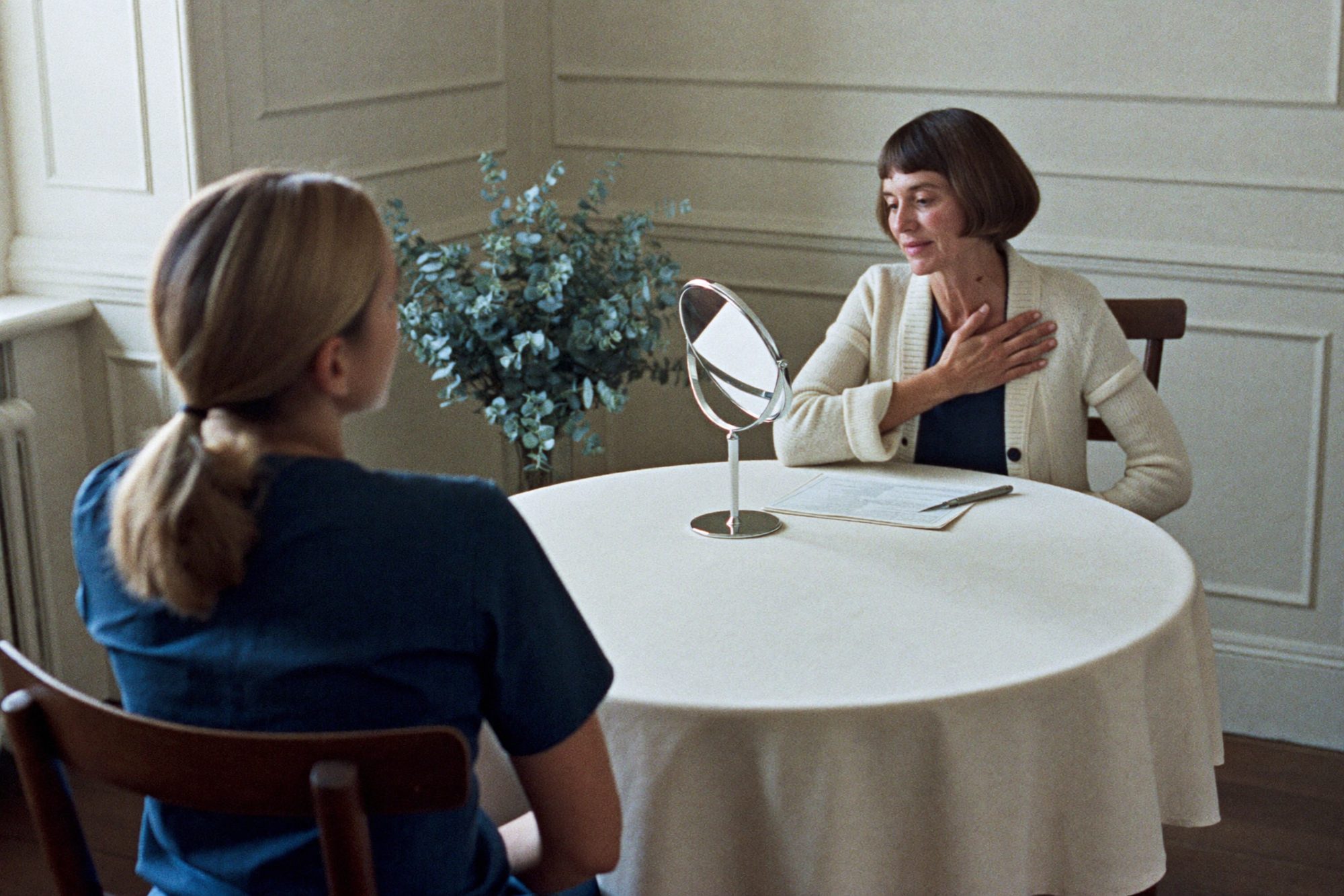 A doctor and a patient talking across a round table at a consultation