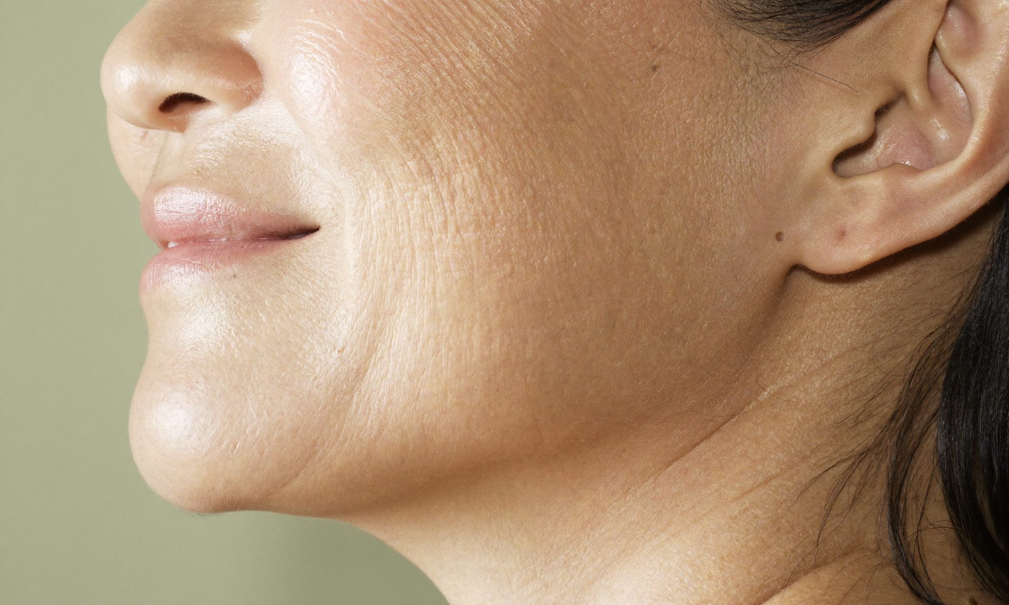 Close-up of a woman's cheek and the first fine smile lines beside her mouth